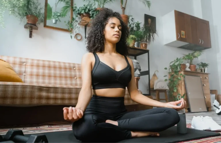 Woman meditating in sunlit living room